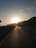 A motorcyclist riding through a scenic mountain road at sunset.