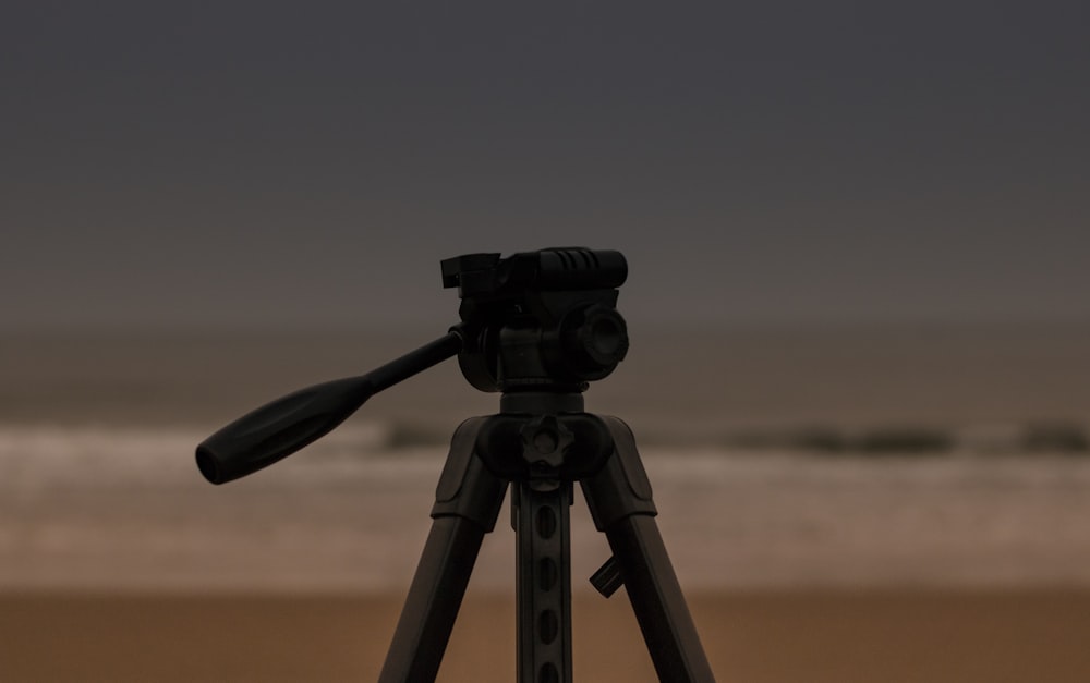 black camera with tripod on brown field during daytime