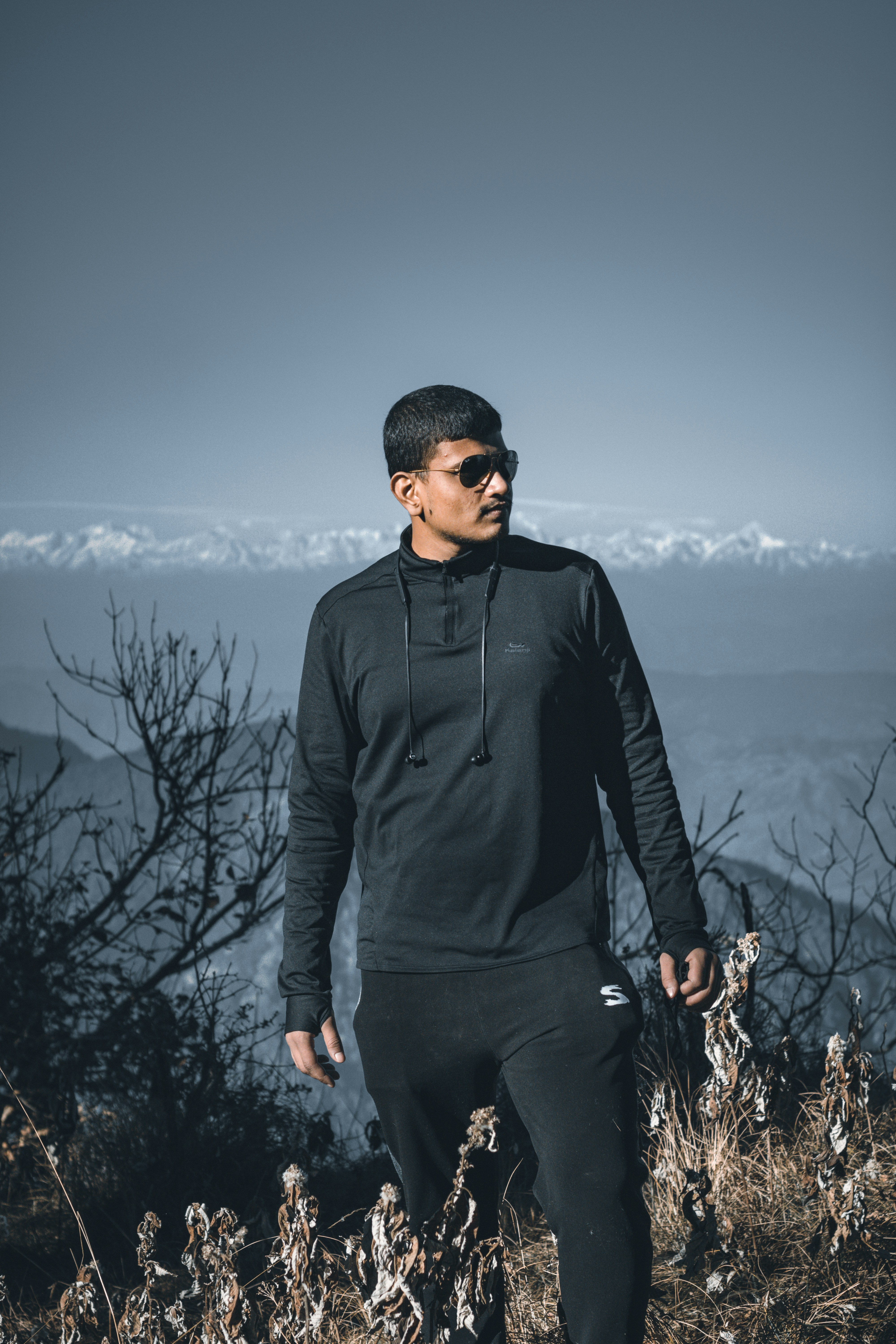 man in black jacket standing near bare tree during daytime