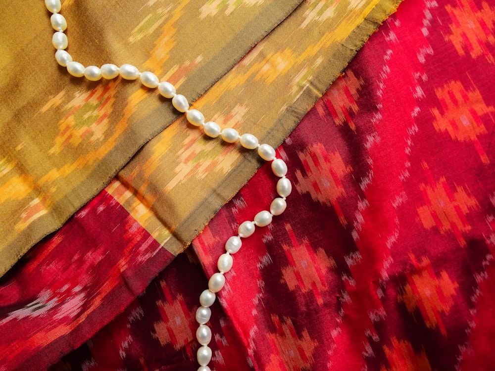 Silberne Halskette auf rotem Textil