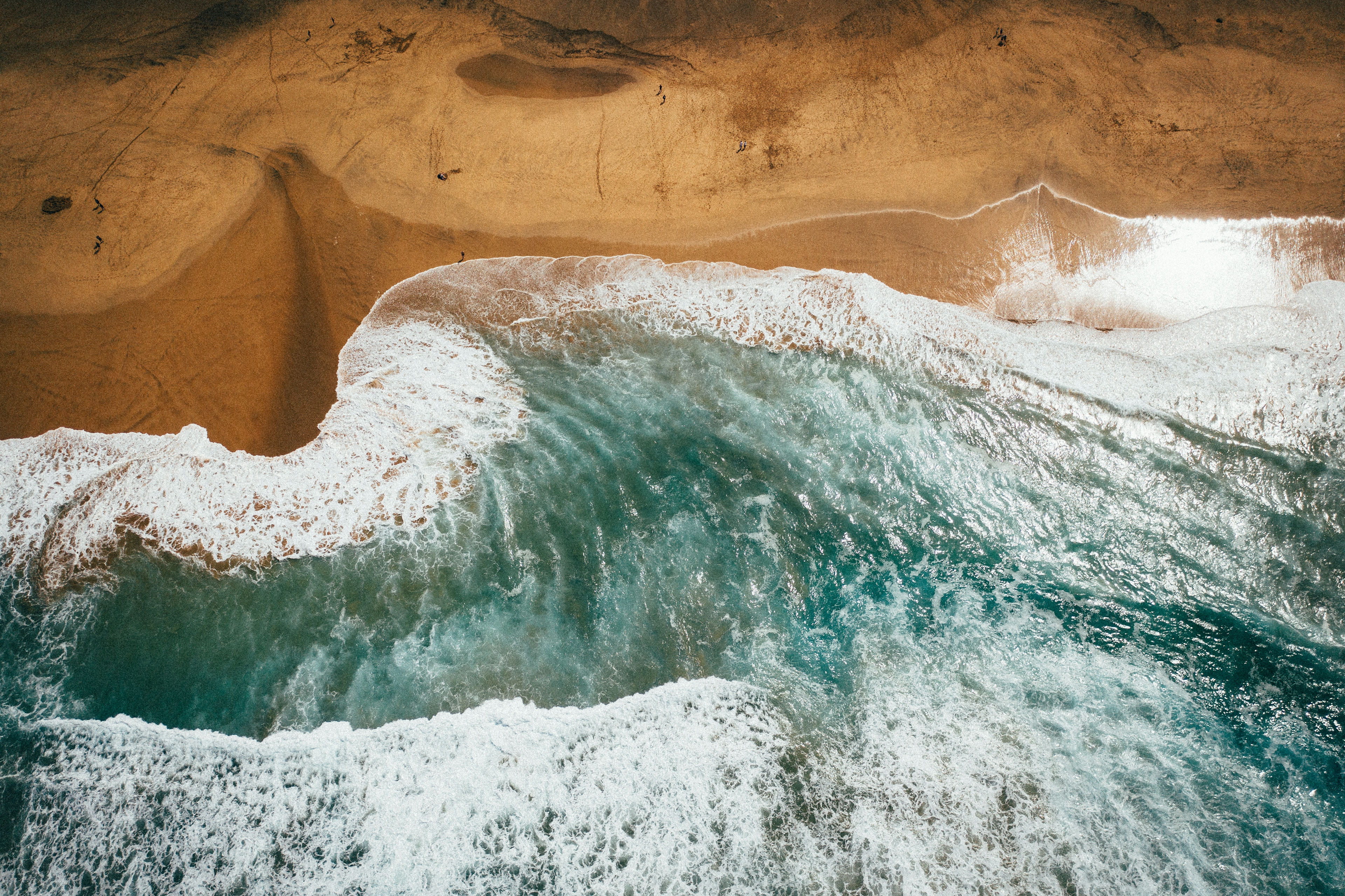 un'onda si infrange sulla sabbia dorata di una spiaggia di fuerteventura