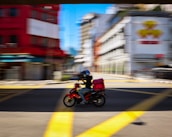 man in red jacket riding motorcycle on road during daytime