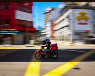 man in red jacket riding motorcycle on road during daytime