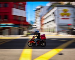 man in red jacket riding motorcycle on road during daytime