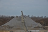 Close-up of a durable black conveyor belt loaded with crushed ore in a mining site