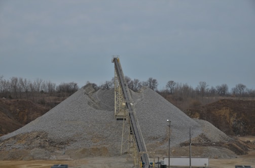 Close-up of a durable black conveyor belt loaded with crushed ore in a mining site