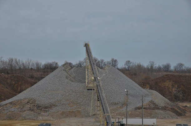 Close-up of raw iron ore chunks on a conveyor belt in a mining facility