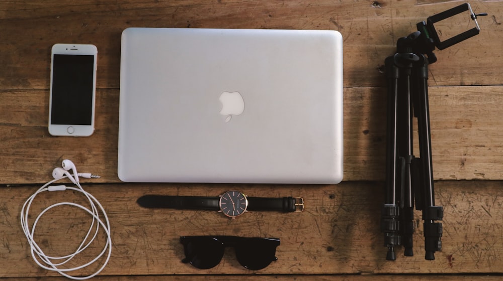 silver macbook on brown wooden table