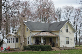 white and brown house near bare trees during daytime