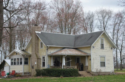 white and brown house near bare trees during daytime