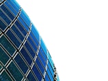 Curved rows of blue and black solar panels against a stark white background.