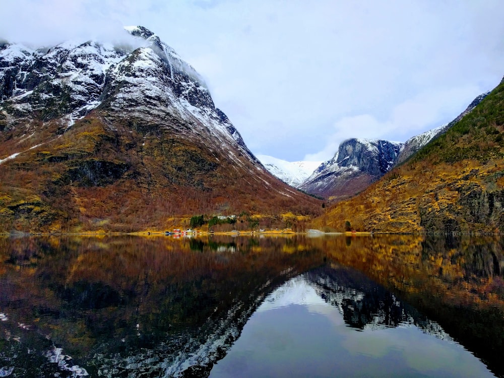 body of water near mountain during daytime