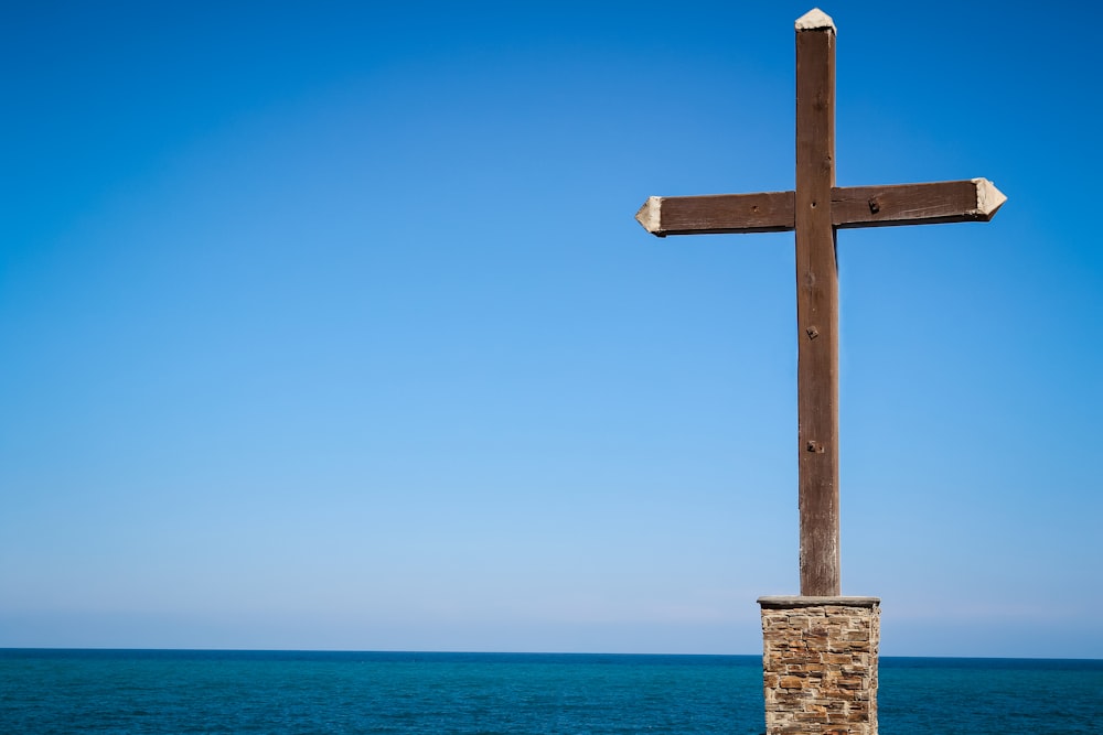 Croix en bois brun sur la plage pendant la journée