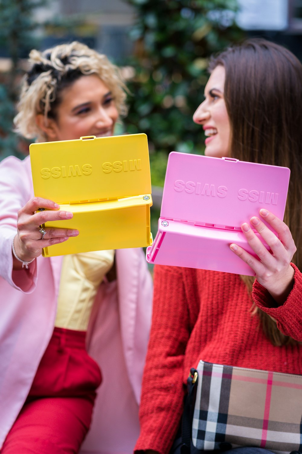 woman in red sweater holding pink folder