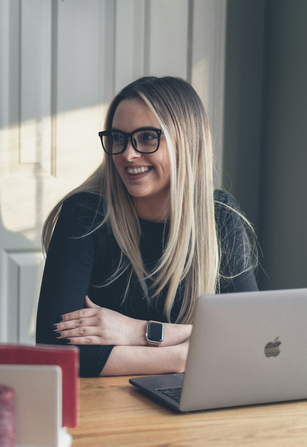 woman in black long sleeve shirt wearing black framed eyeglasses sitting on chair in front of while