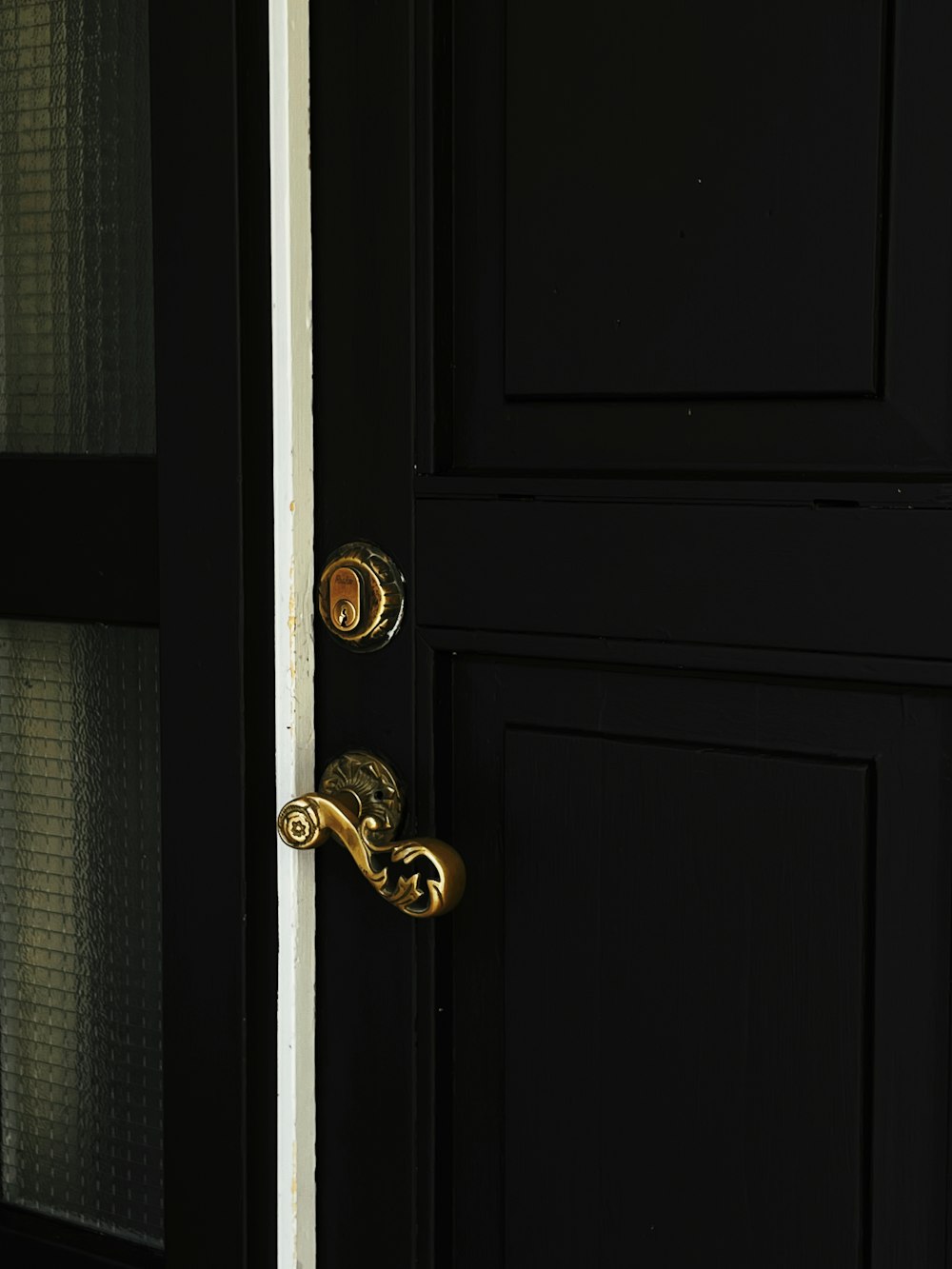 gold door knob on black wooden door