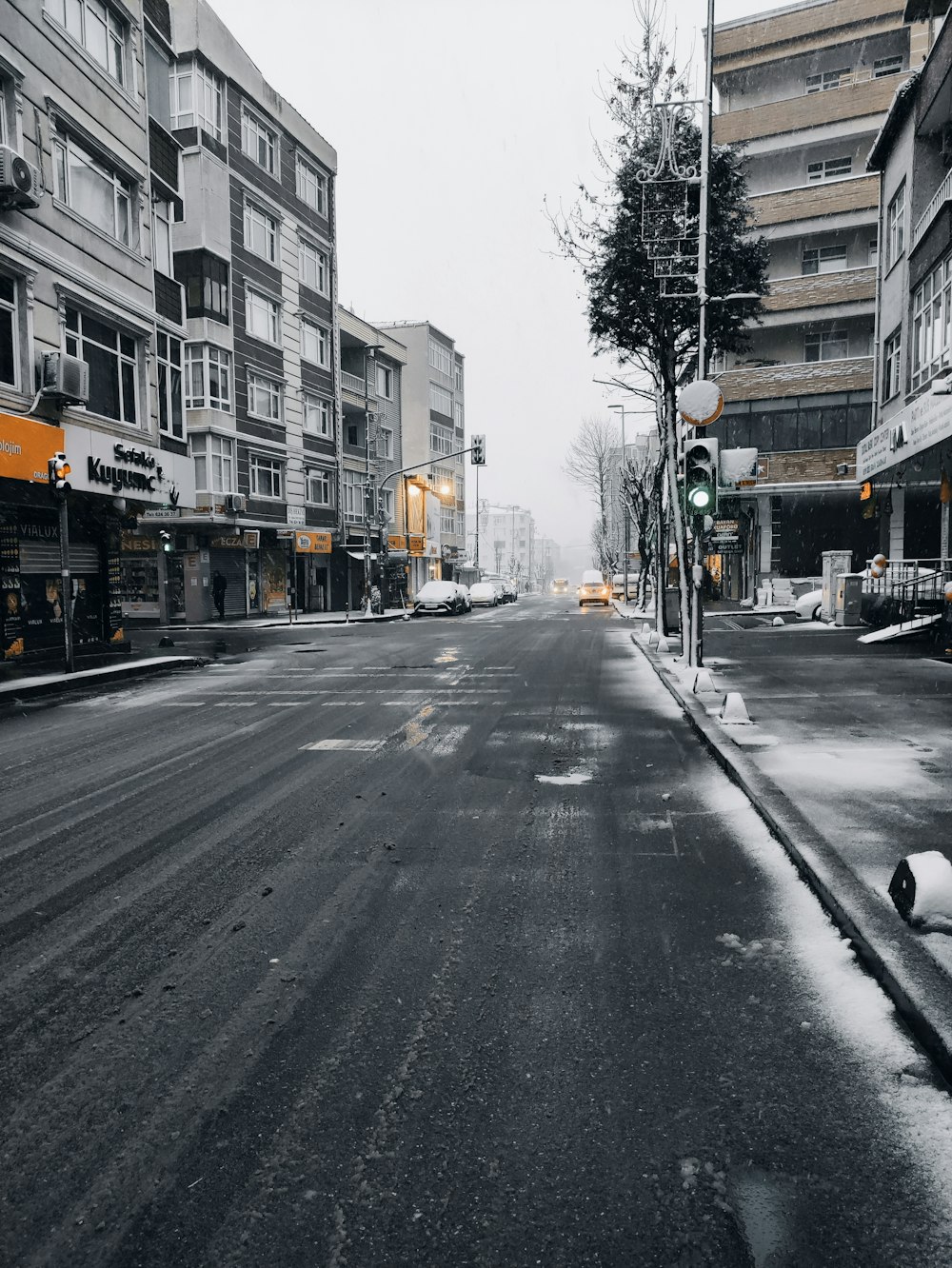 cars on road between buildings during daytime