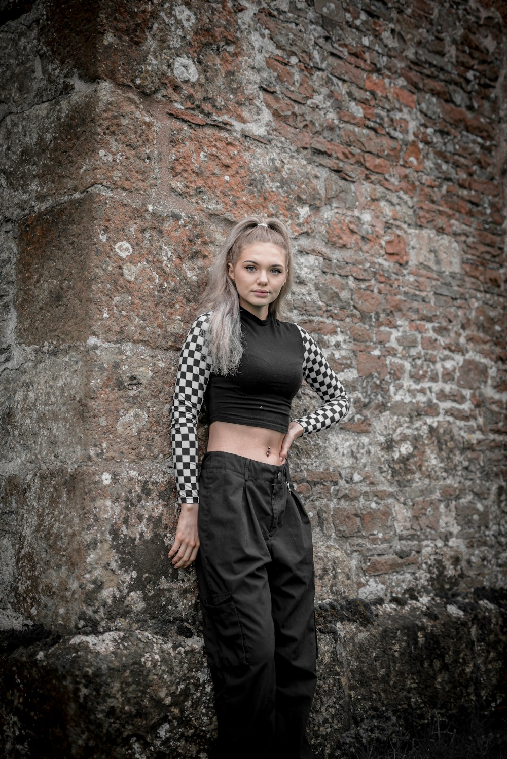 woman in black and white polka dot long sleeve shirt and black skirt standing beside brown