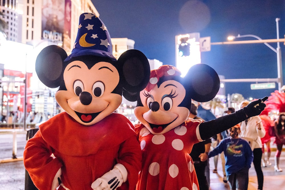 mickey mouse mascot standing near people in mickey mouse costume