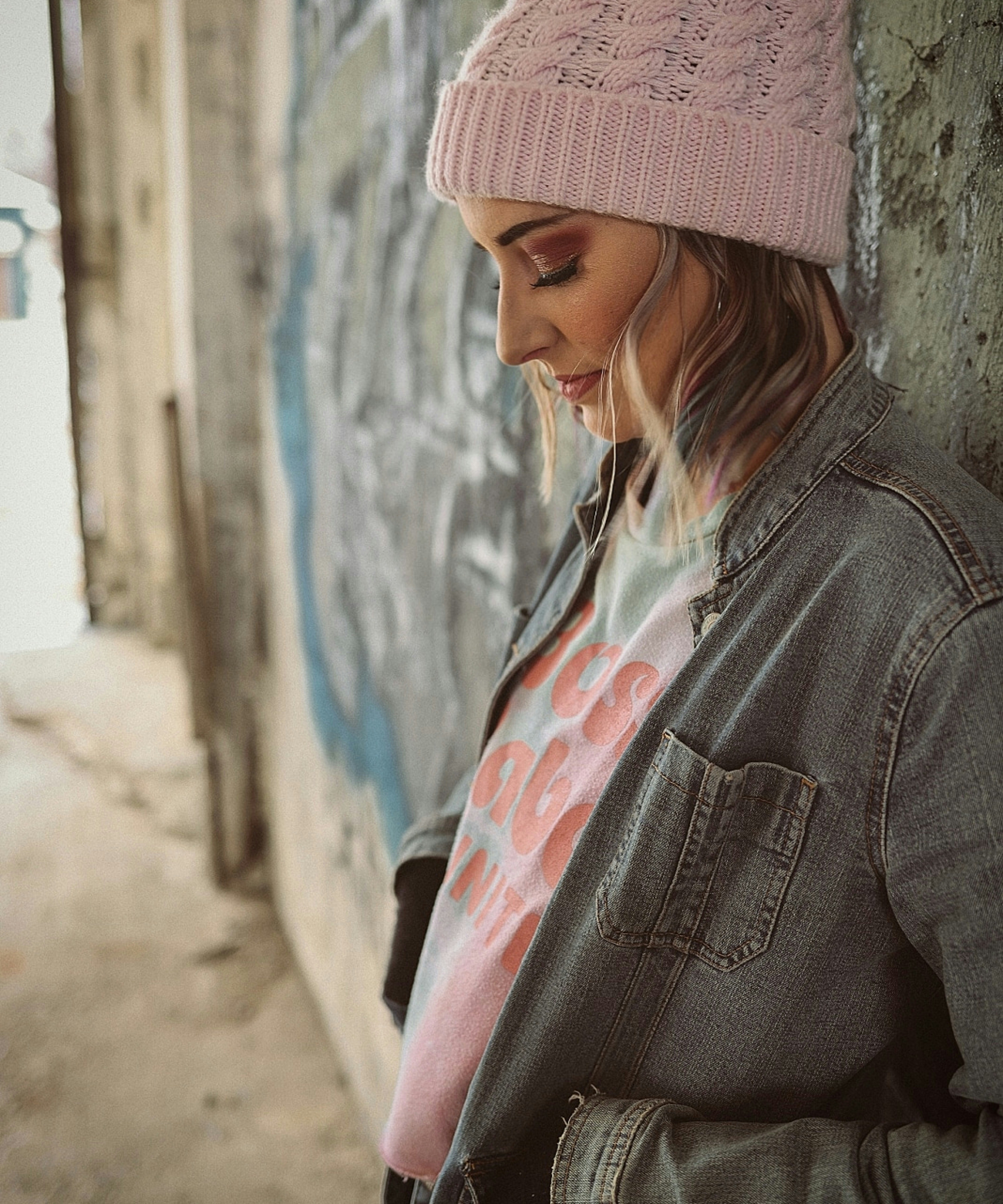woman in gray denim jacket wearing pink knit cap