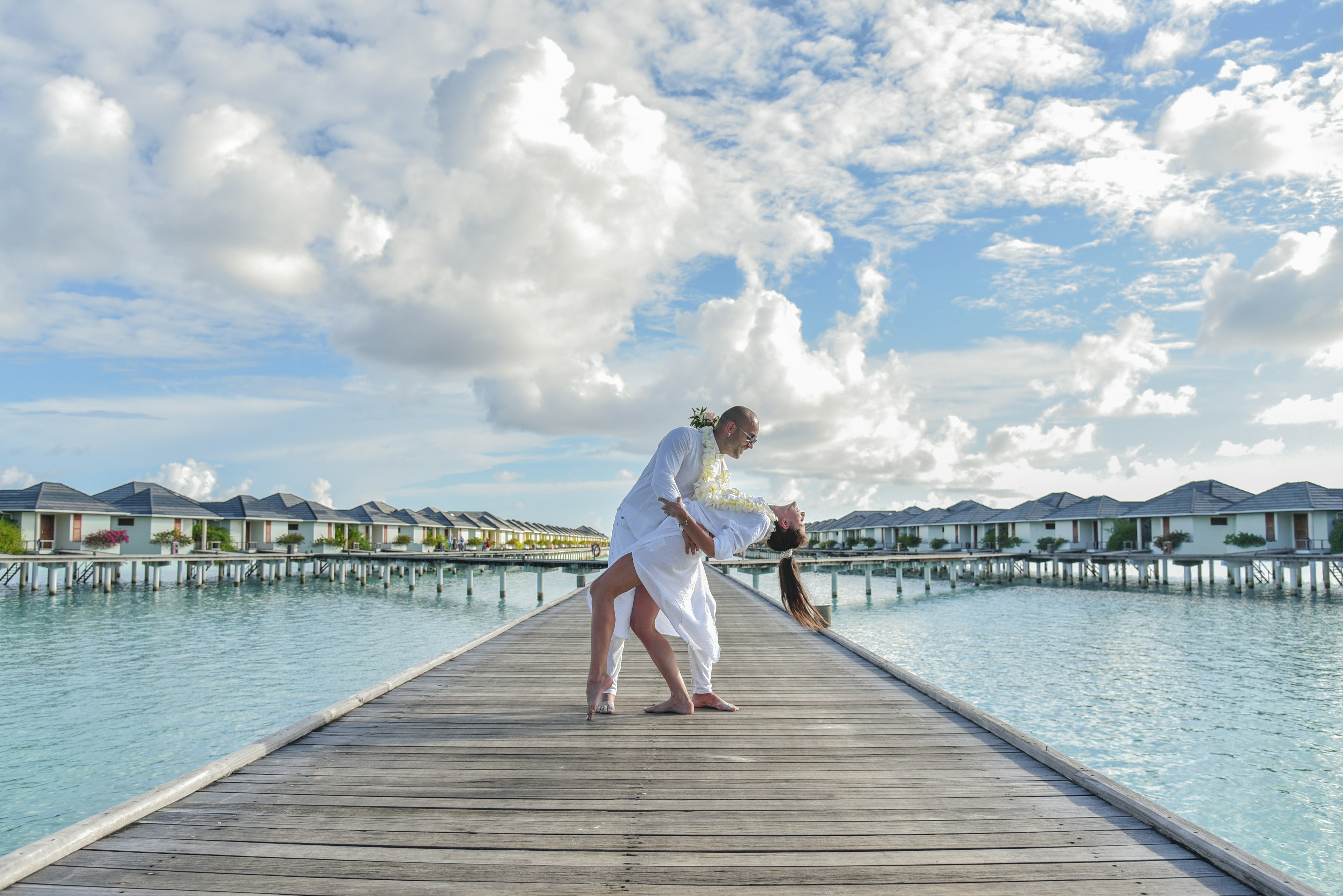 woman in white dress standing on wooden dock during daytime