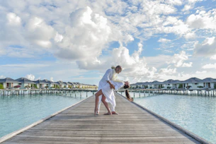woman in white dress standing on wooden dock during daytime