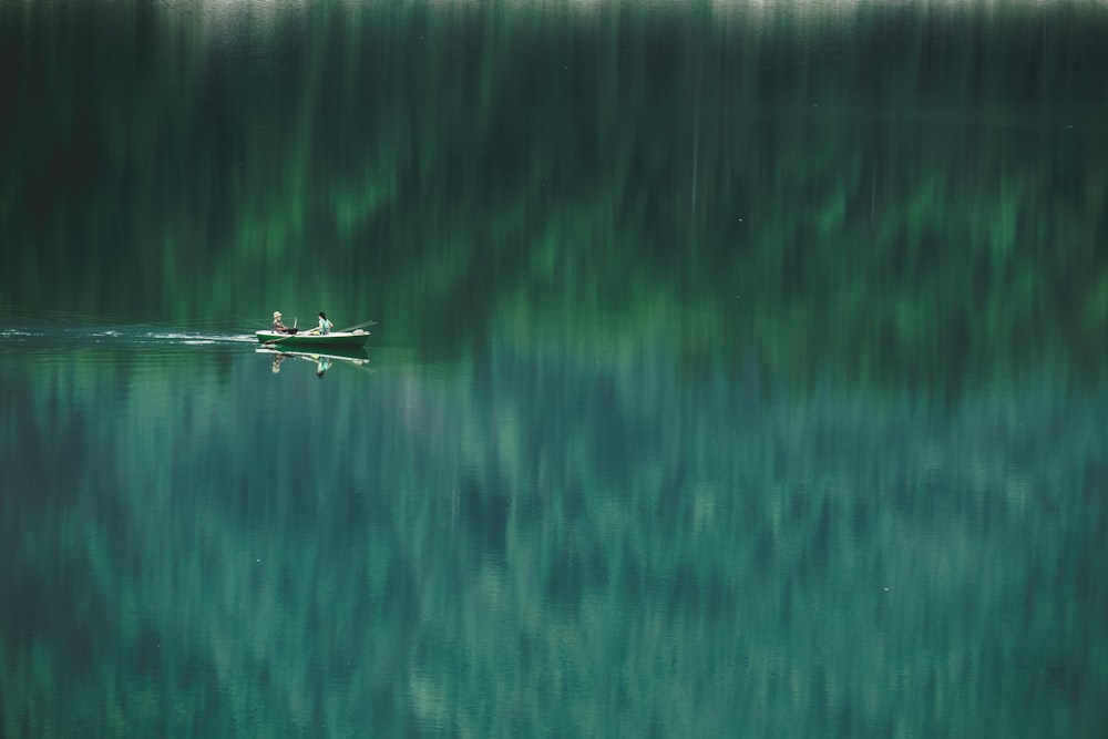 person riding on boat on body of water during daytime