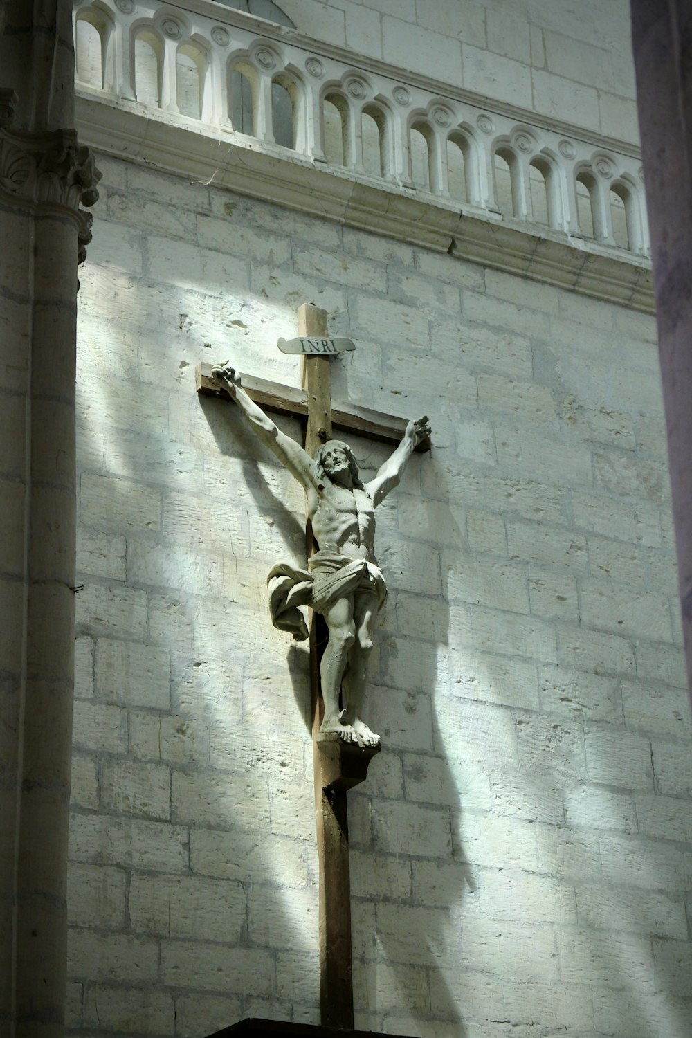 Estatua de hormigón del ángel en la pared de hormigón gris