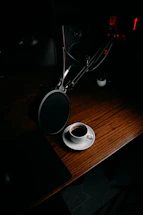 A softly lit desk with a vintage microphone and handwritten notes scattered around.