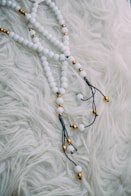 black and brown beaded necklace on white textile