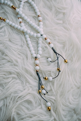 black and brown beaded necklace on white textile
