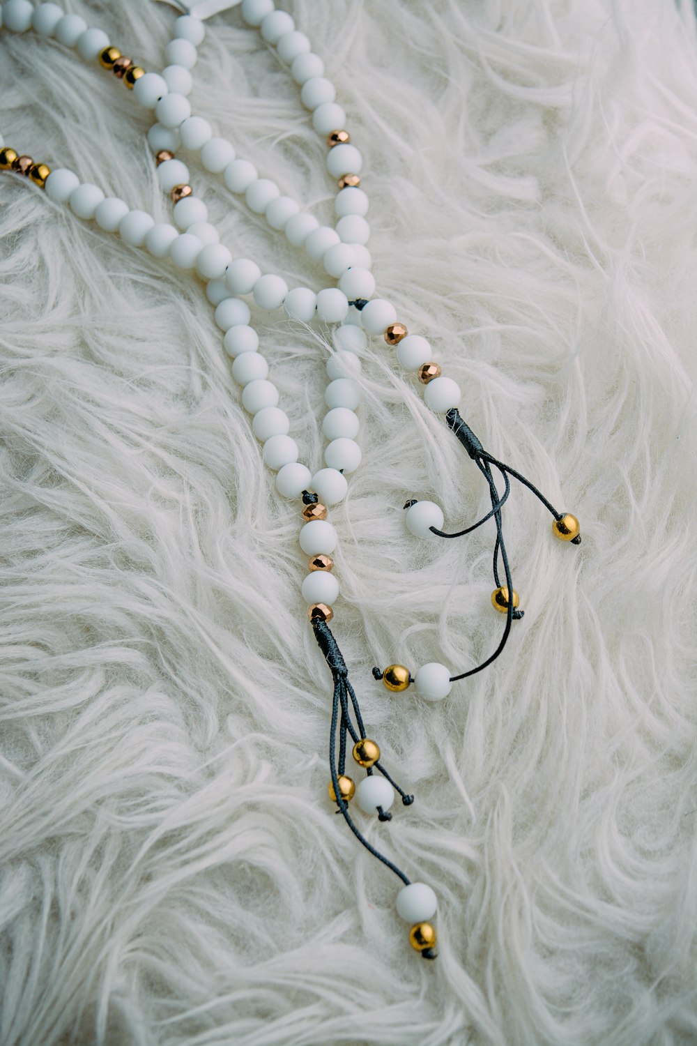 black and brown beaded necklace on white textile