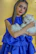 A sleek cat lounging gracefully wearing a vibrant handmade dress in natural light.