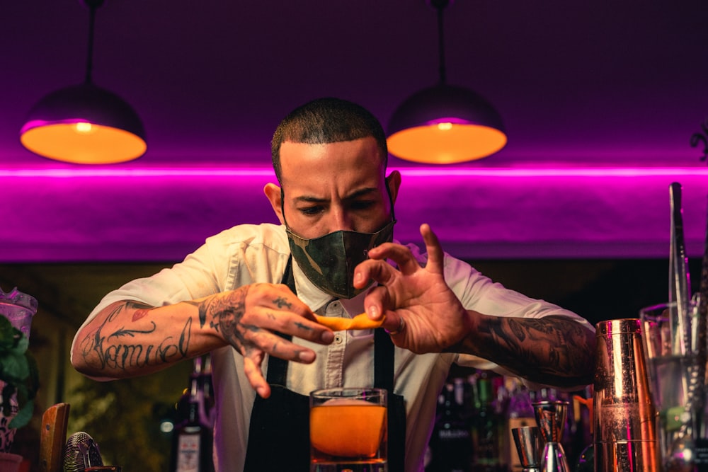 man in white dress shirt holding clear drinking glass