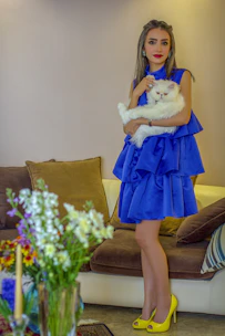 A cute cat modeling a perfectly fitted custom-made dress in a bright room.