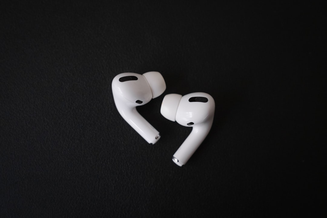 white plastic tool on black textile, A pair of Apple Airpods Pro on a black background
