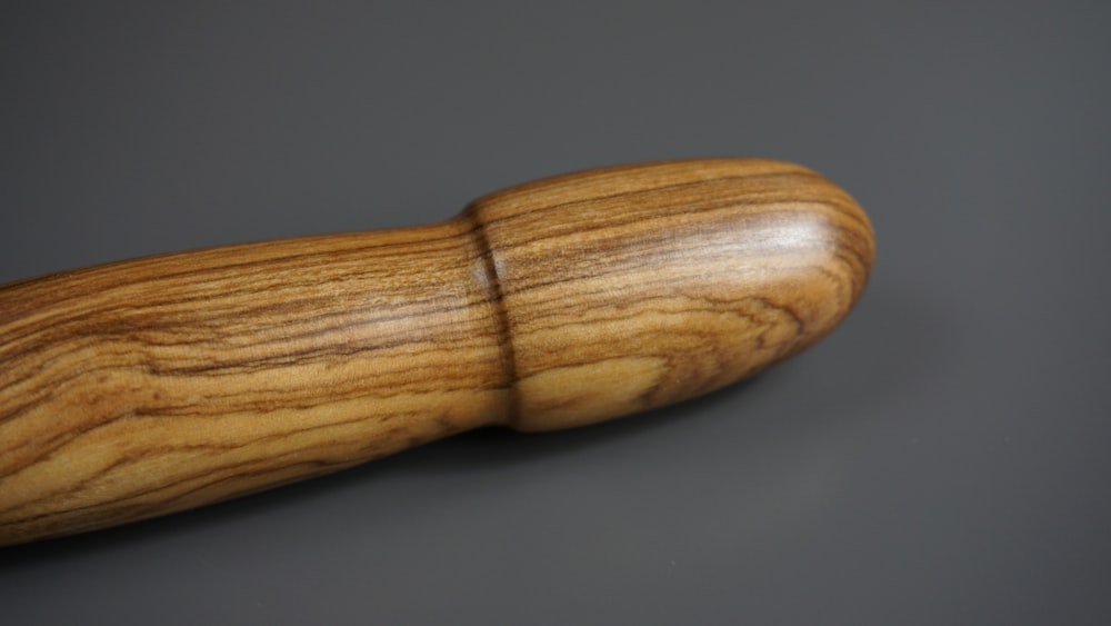 brown wooden rolling pin on black surface