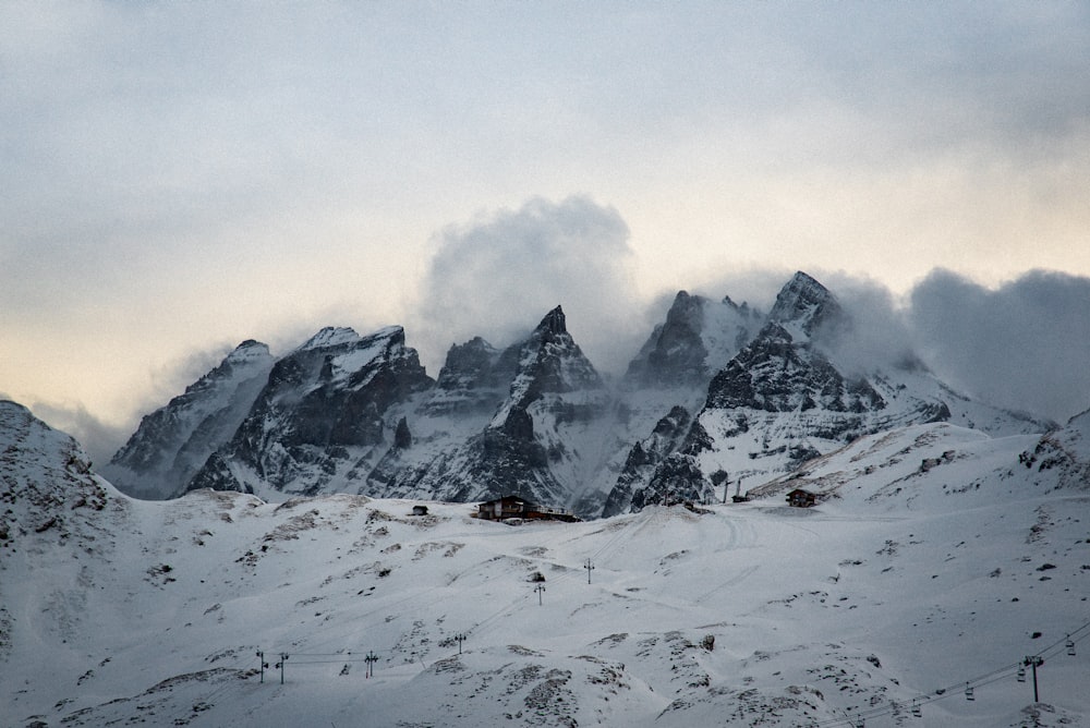 snow covered mountain under white clouds during daytime