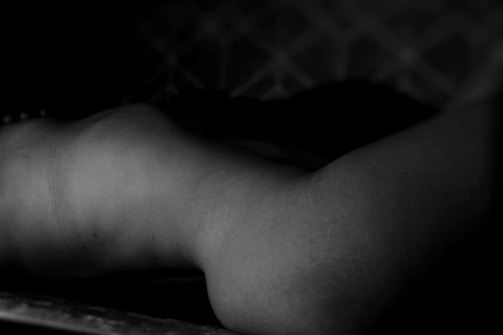 Subtle monochrome photograph of a delicate sculptural form in soft natural light with muted shadows.