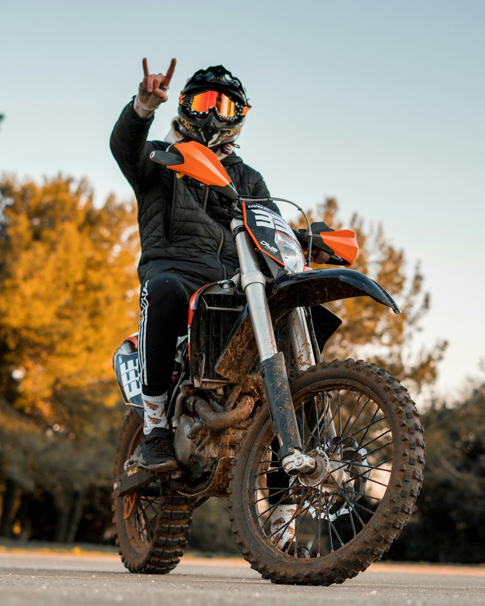 man in orange helmet riding on black and white motorcycle during daytime