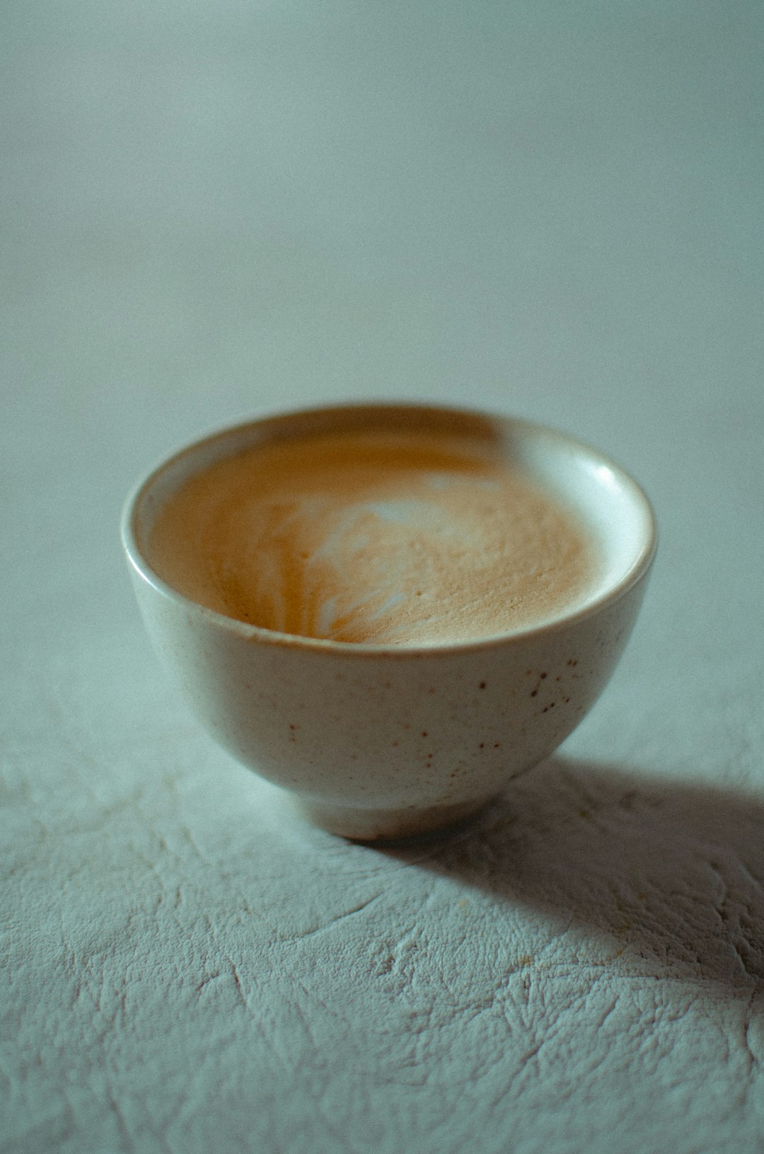 white ceramic bowl on white textile