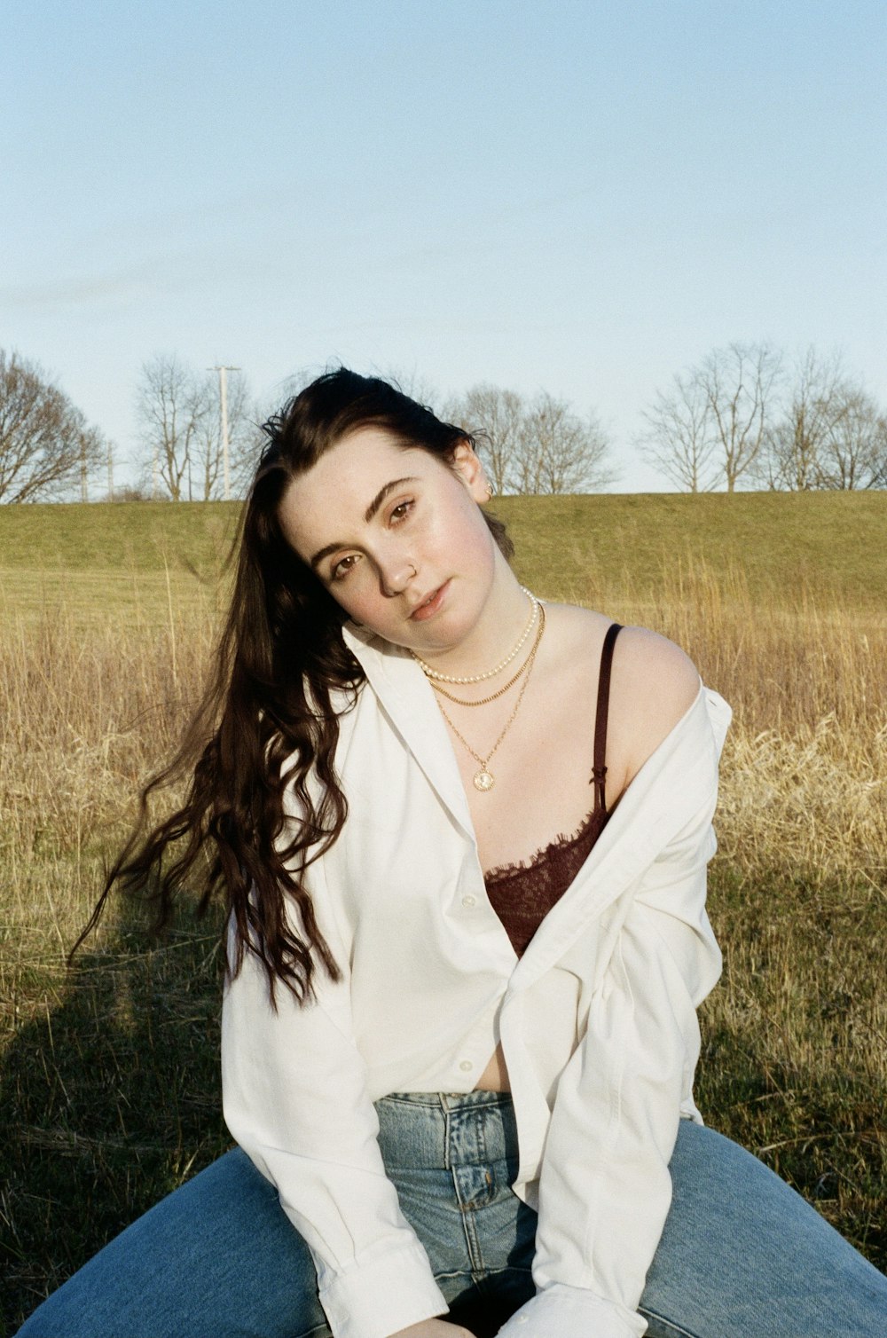 woman in white long sleeve shirt standing on green grass field during daytime