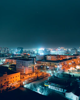 Evening cityscape showing residential and commercial buildings illuminated in Vilnius.
