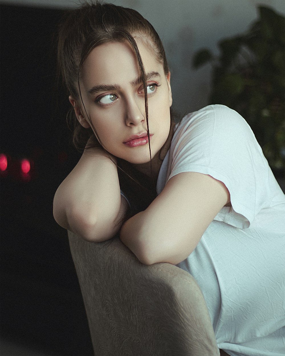 woman in white t-shirt lying on gray sofa