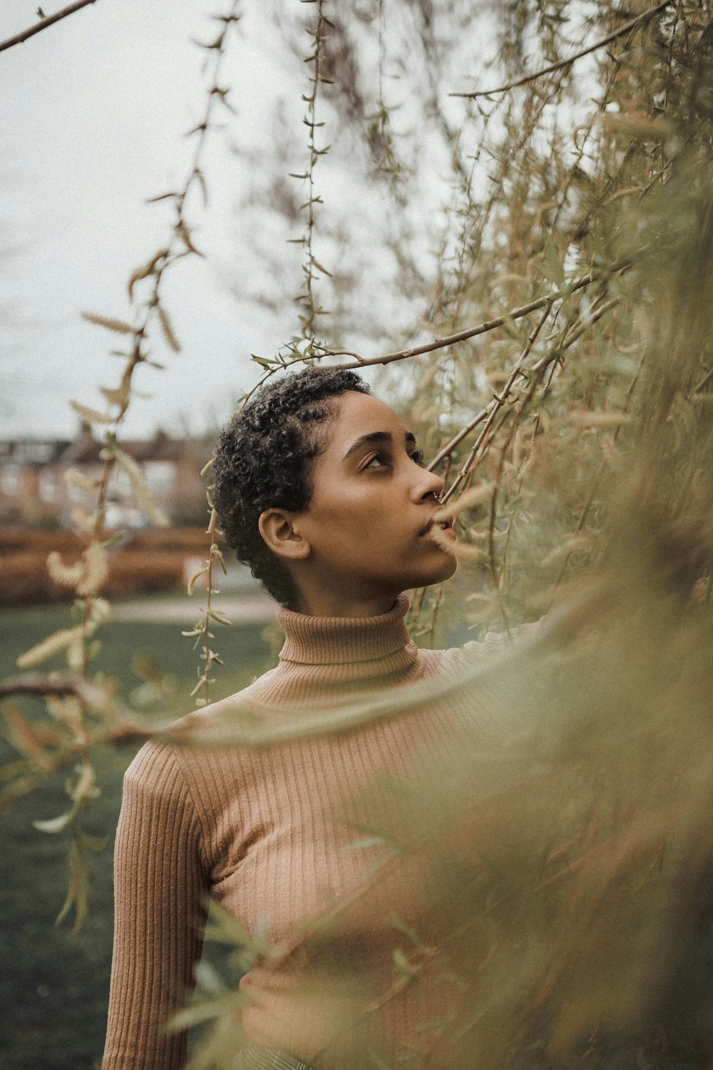 woman in beige knit sweater standing near brown leafless tree during daytime