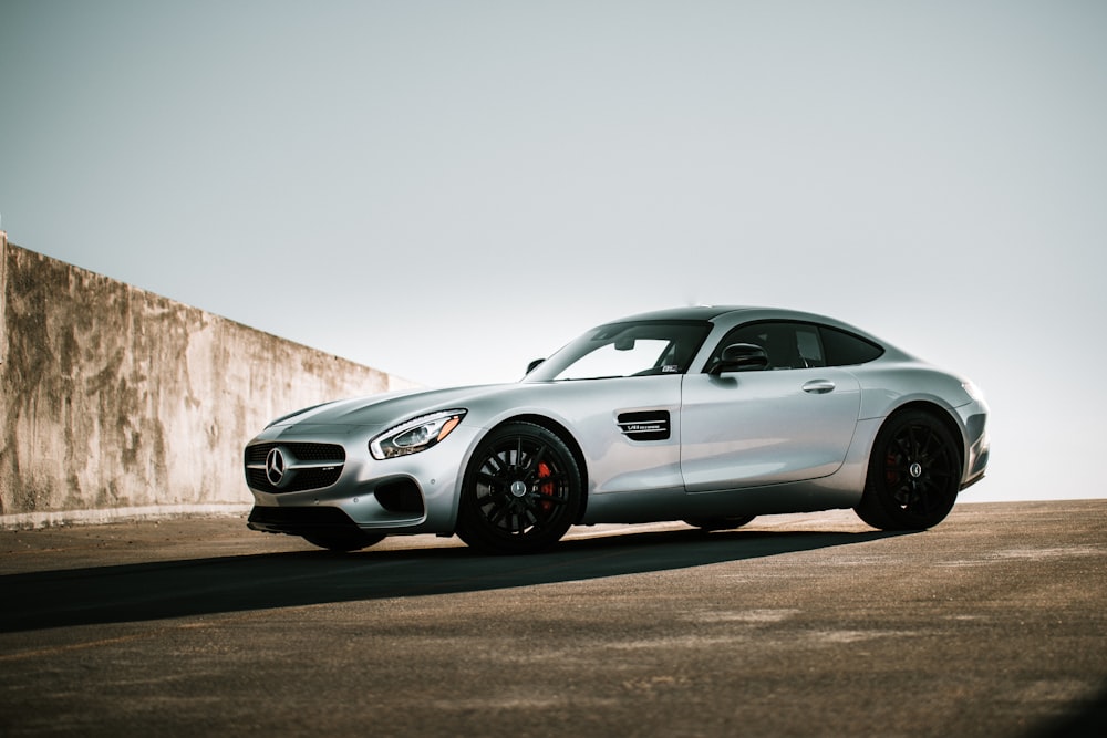 white mercedes benz coupe parked on gray asphalt road