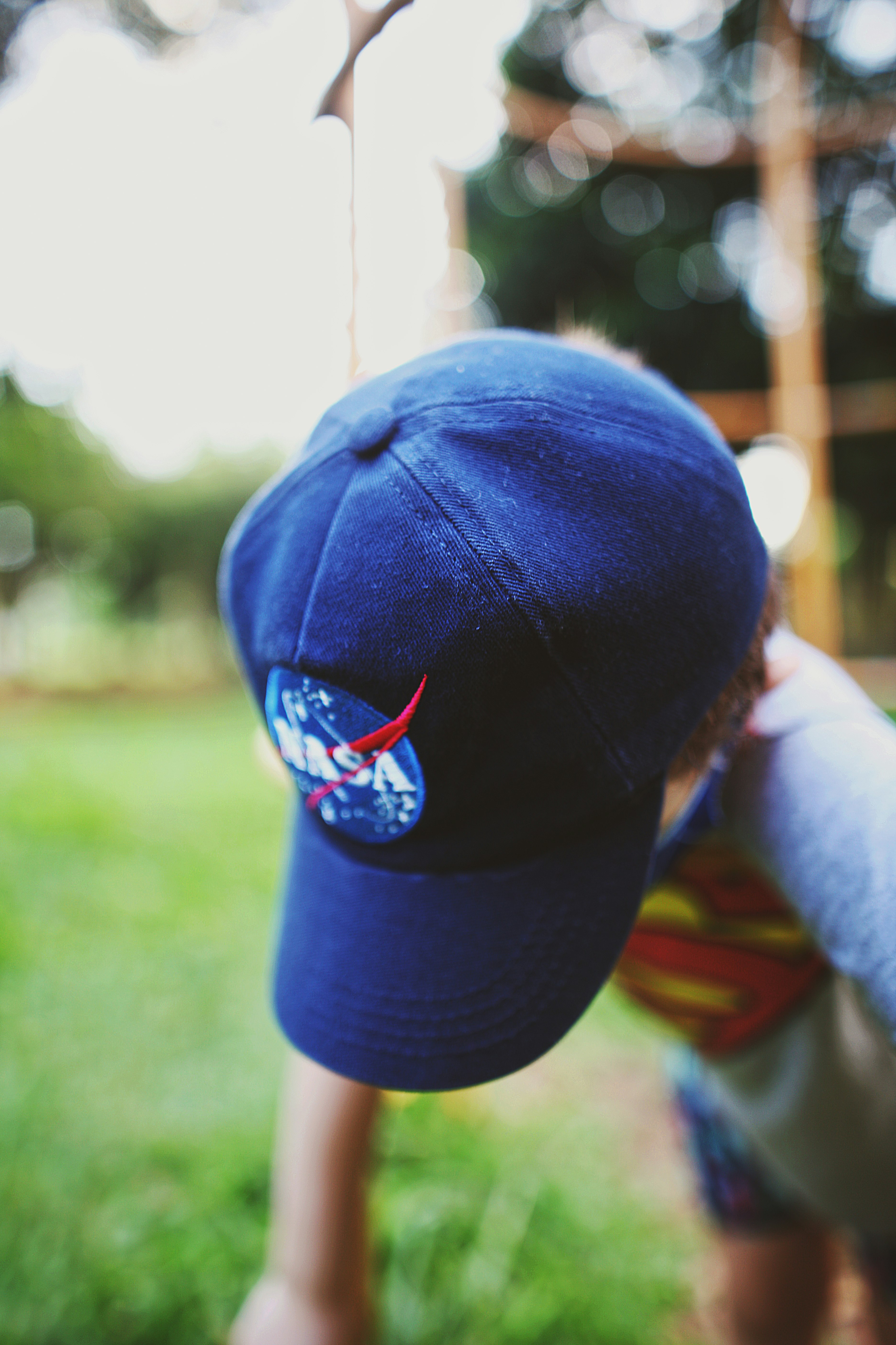 person holding blue and red baseball cap
