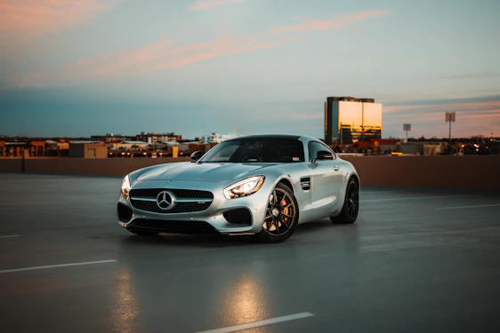 A sleek car parked in front of Melbourne’s city skyline at sunset, reflecting trust and professionalism.