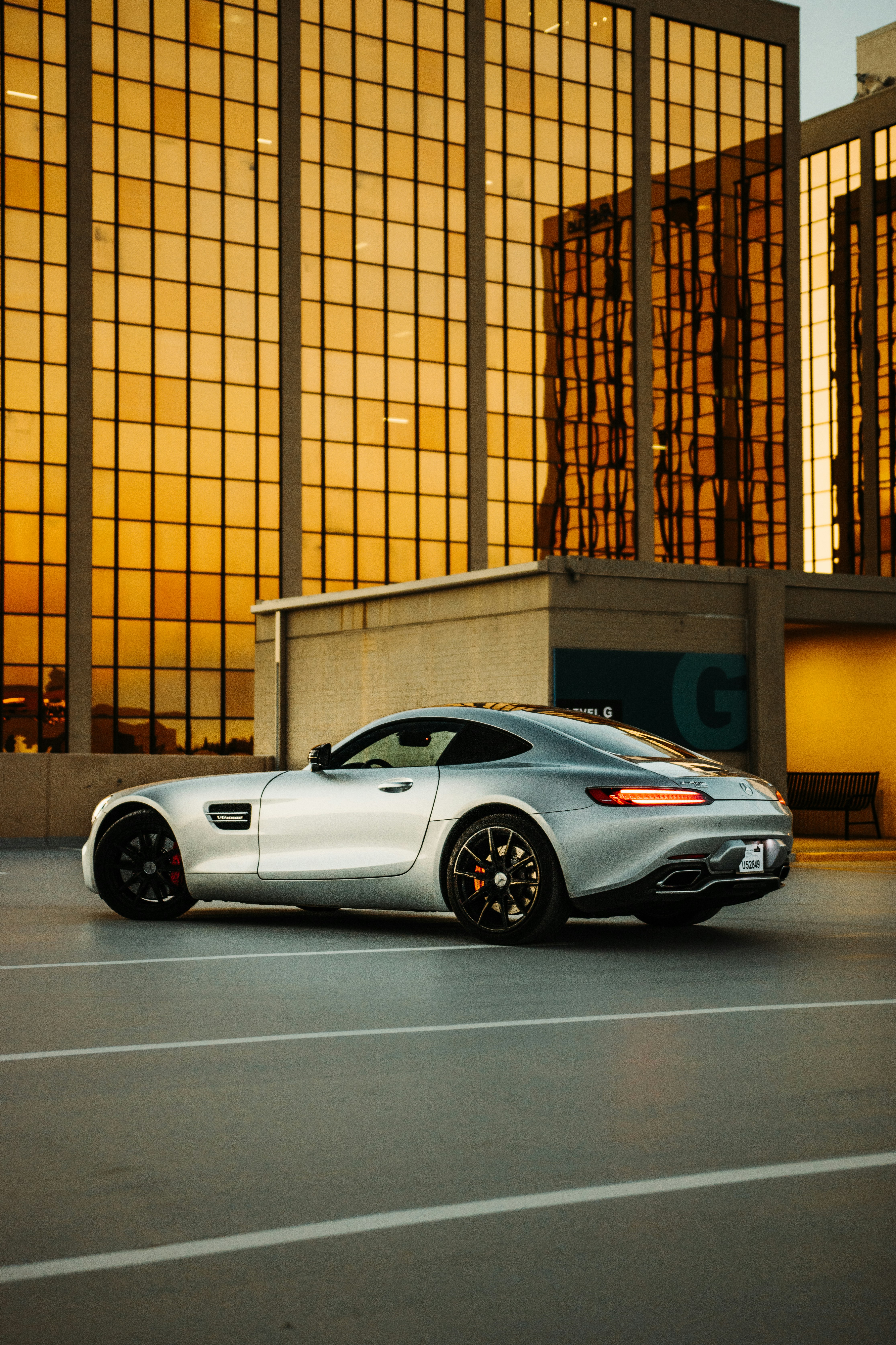 white porsche 911 parked in front of brown building