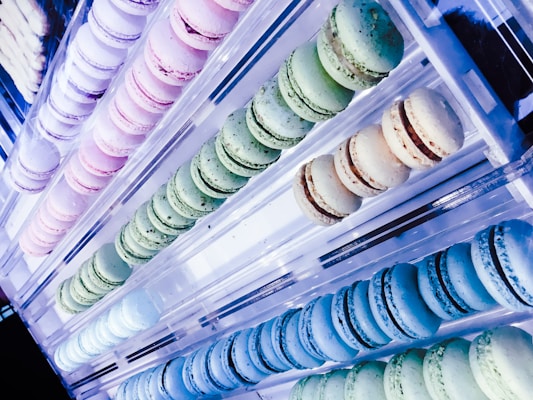 A beautifully arranged display of assorted macarons in pastel colors.